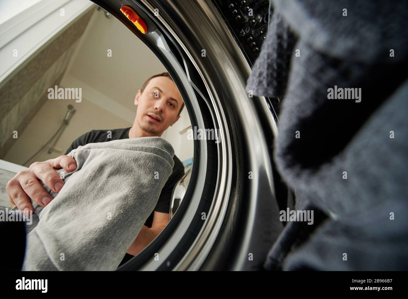 Man loading washing maching view from inside Stock Photo