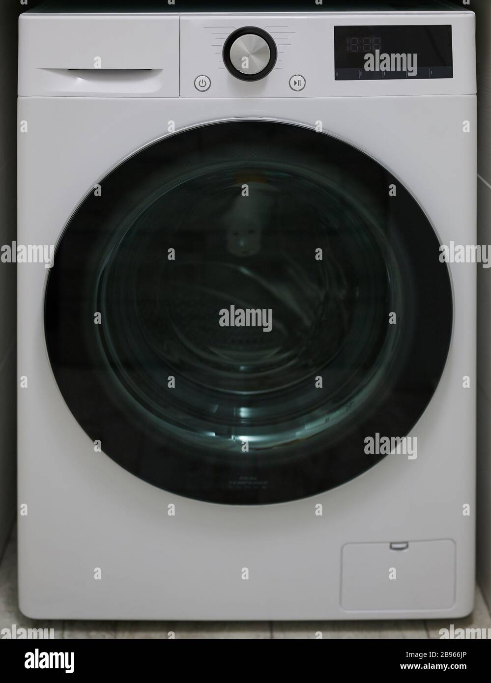 New electronic washing machine front view with dark glass door Stock Photo
