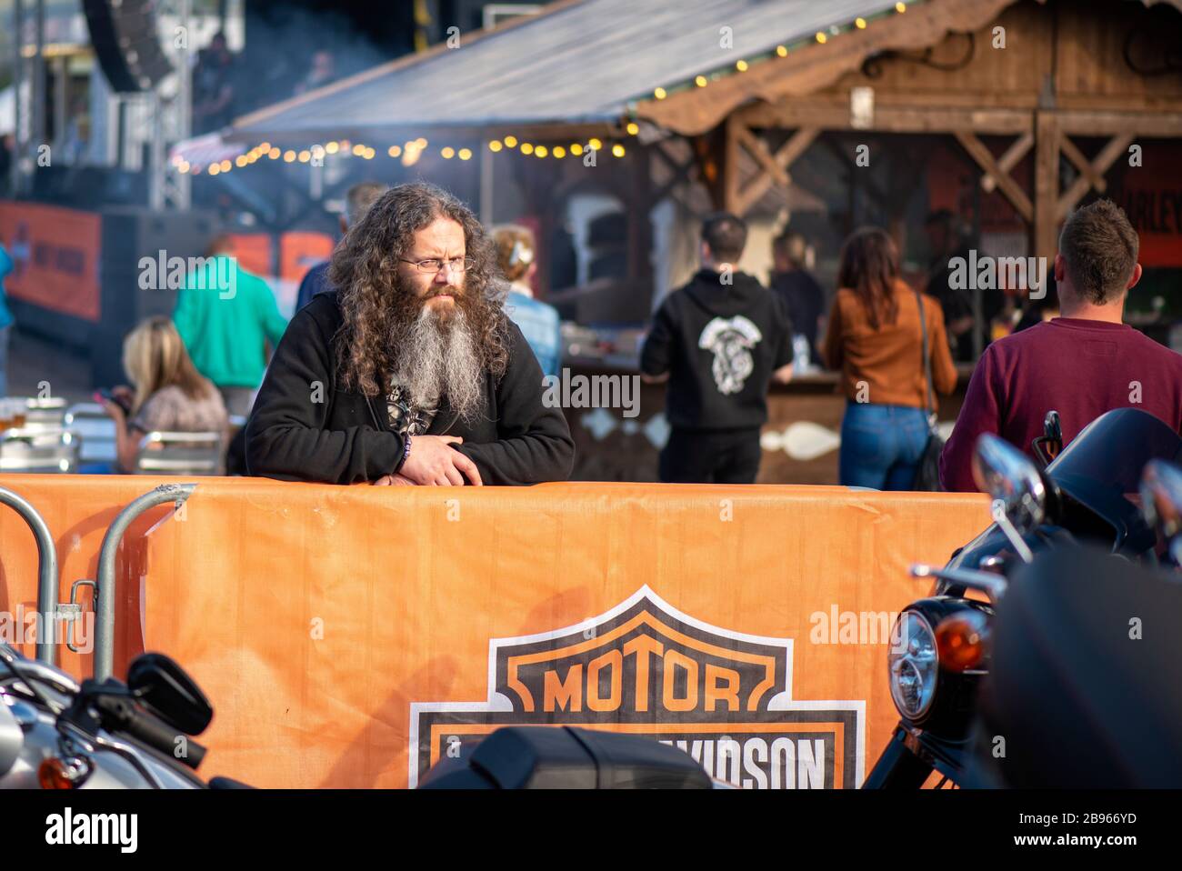 "Harley Davidson" Bike Fest gathering. A biker with long hair and beard looking at Harley