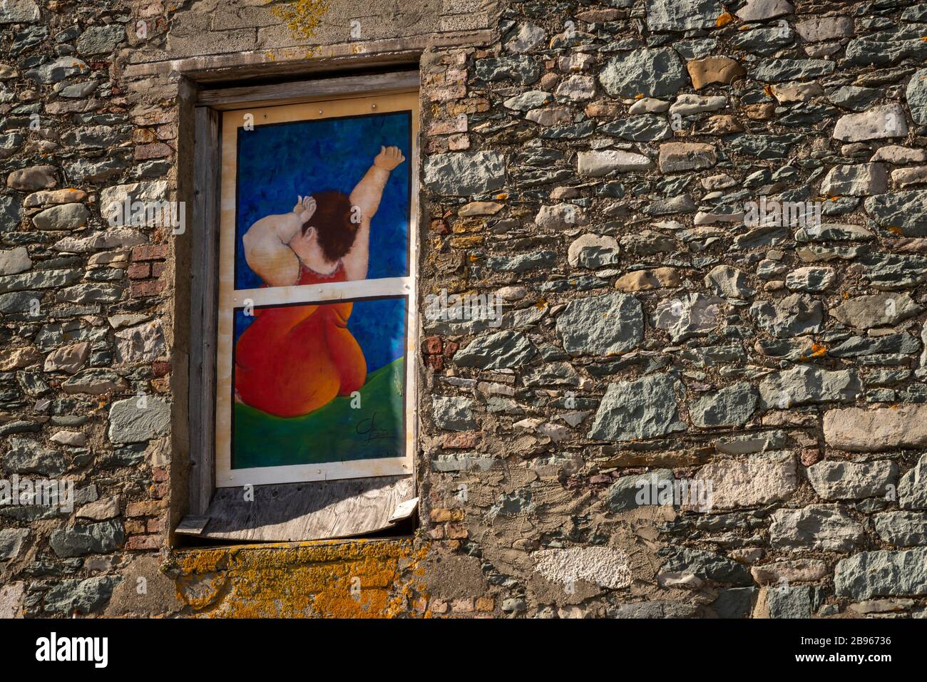 Painted window of house stone wall depicting woman after waking up as urban art in Killarney, Ireland Stock Photo