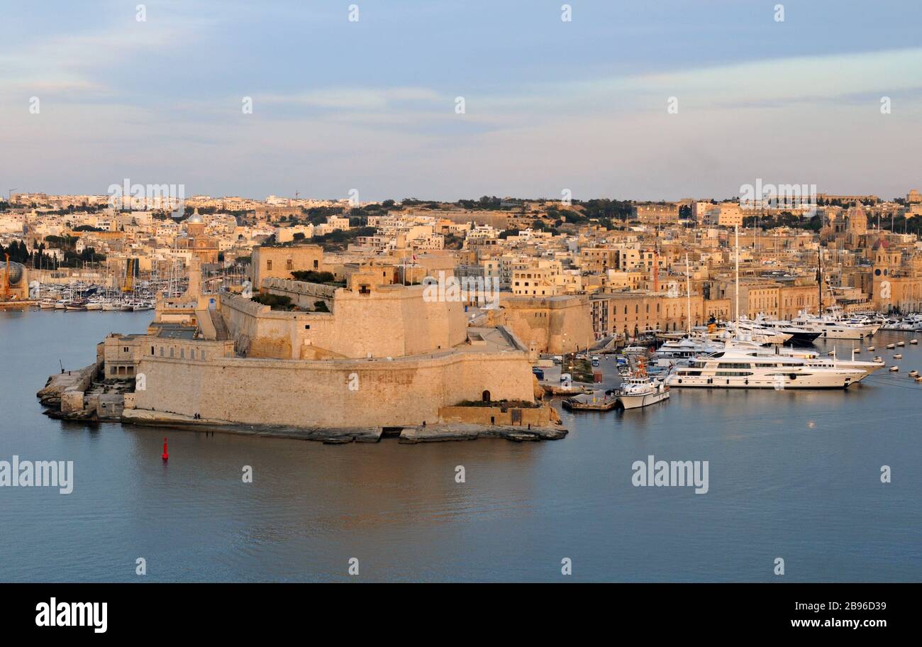 View of the Grand Harbour, Fort St. Angelo and Birgu, Malta from Valletta at dusk. Also known as Vittoriosa, Birgu is one of the Three Cities. Stock Photo