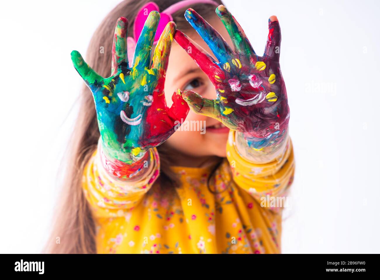 Little happy student girl showing painted hands - childhood and drawing concept, education and art. Stock Photo