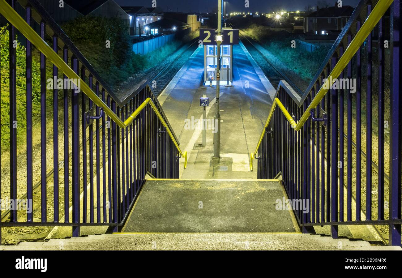 Empty suburban railway station (with no wheelchair access) at night. UK Stock Photo