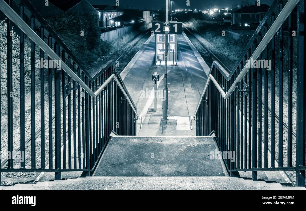 Empty suburban railway station (with no wheelchair access) at night. UK Stock Photo