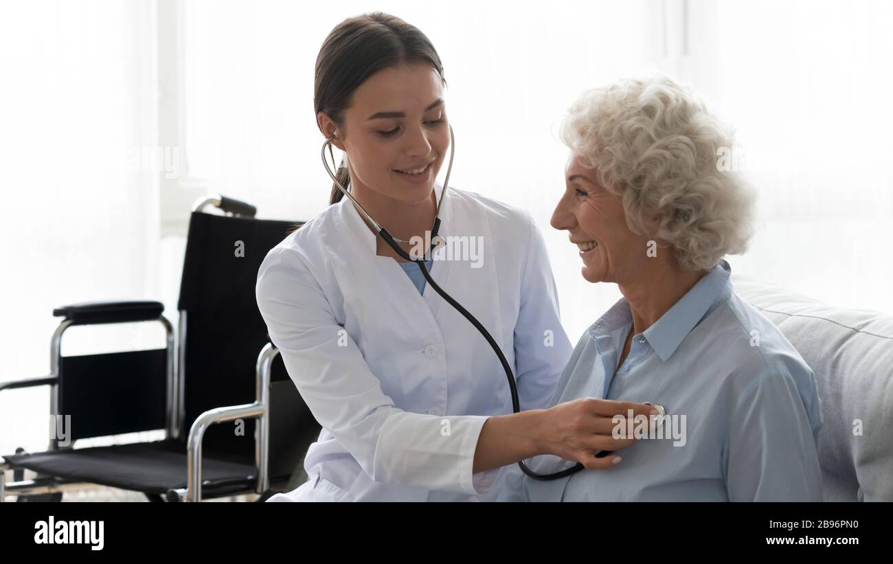 Female caregiver check heart rate of elderly patient Stock Photo