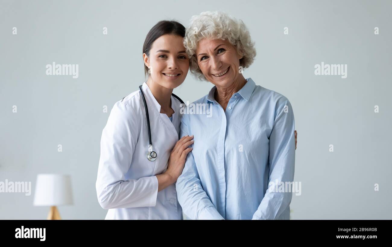 Portrait of senior woman posing with female caregiver Stock Photo