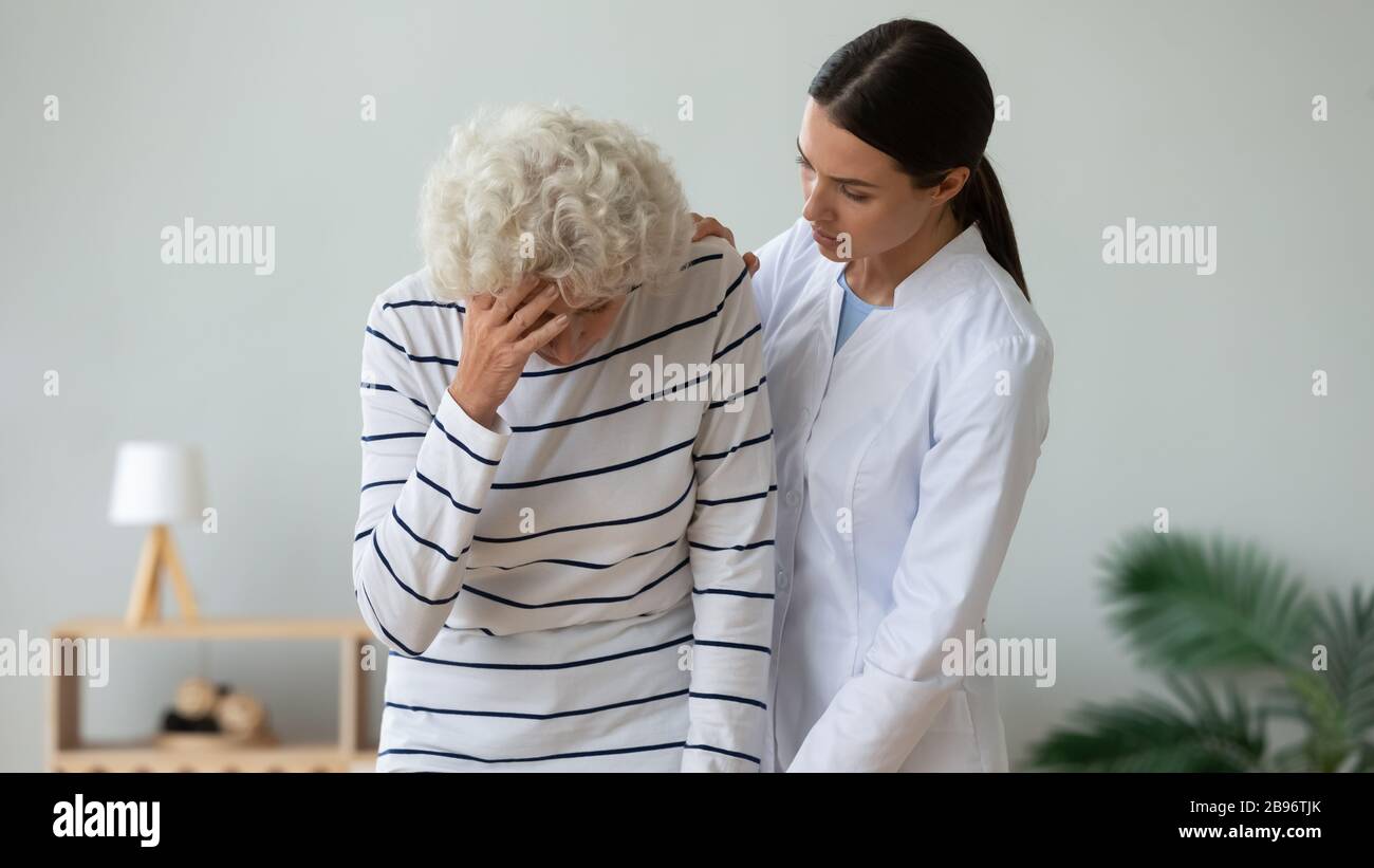 Supportive female caregiver help unhealthy senior patient Stock Photo