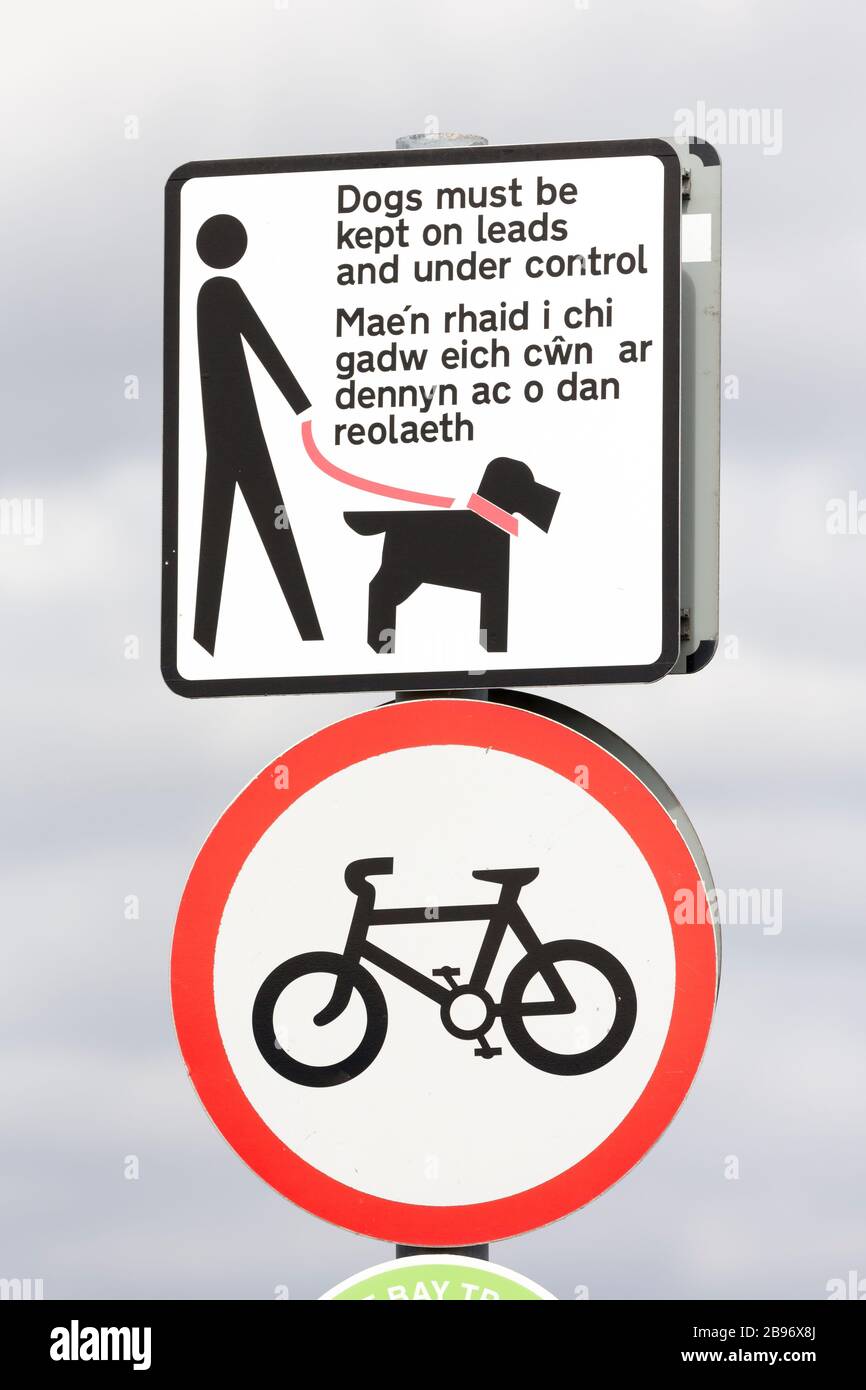 Sign dogs must be kept on leads and under control in English and Welsh and a no cycling sign, Cardiff Bay, Wales, UK Stock Photo