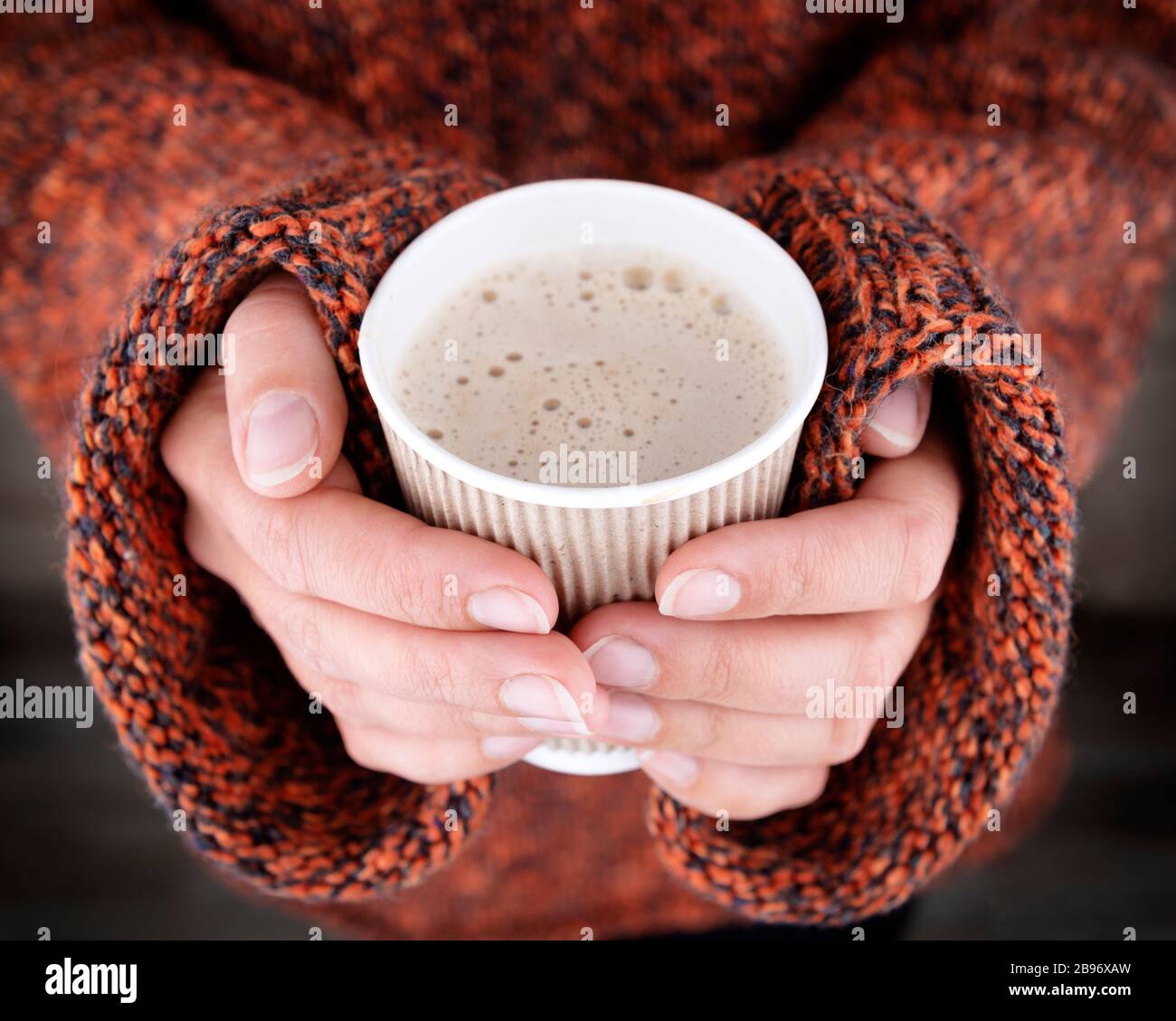 Woman hands in an oversize sweater holding a cup of coffee. Hot drink ...