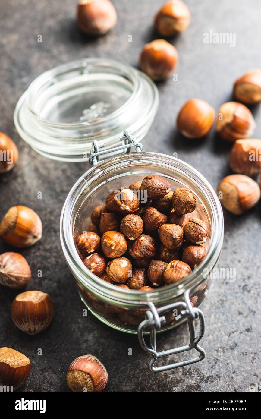 Peeled hazelnuts in jar on kitchen table. Stock Photo