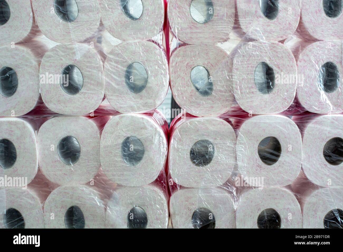 A large stack of toilet paper. A stockpile toilet paper with pink print in packaging. Stock Photo