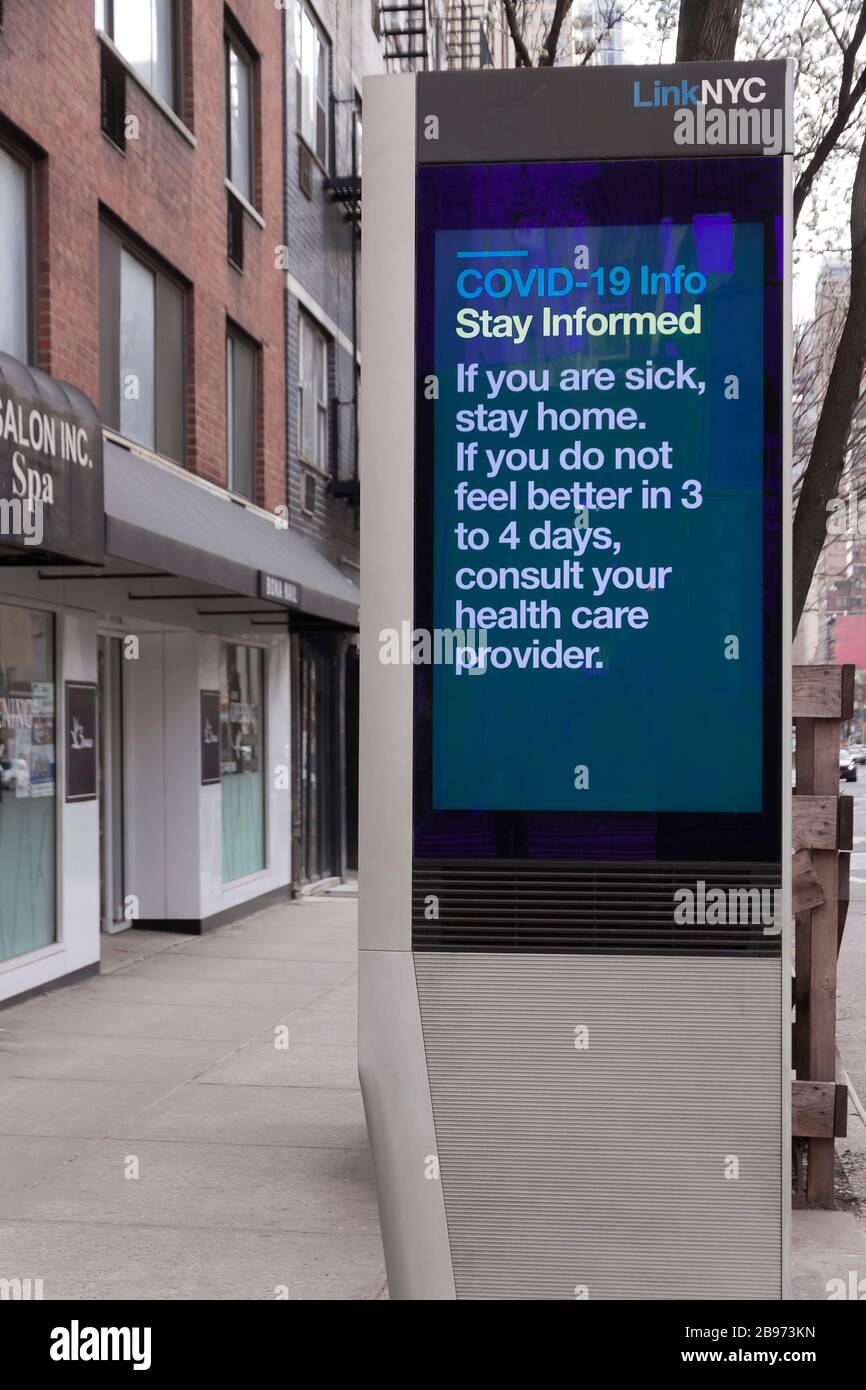 LinkNYC digital kiosk sign on sidewalk displaying Covid-19 (coronavirus) tips and advice about quarantine to New Yorkers. Stock Photo