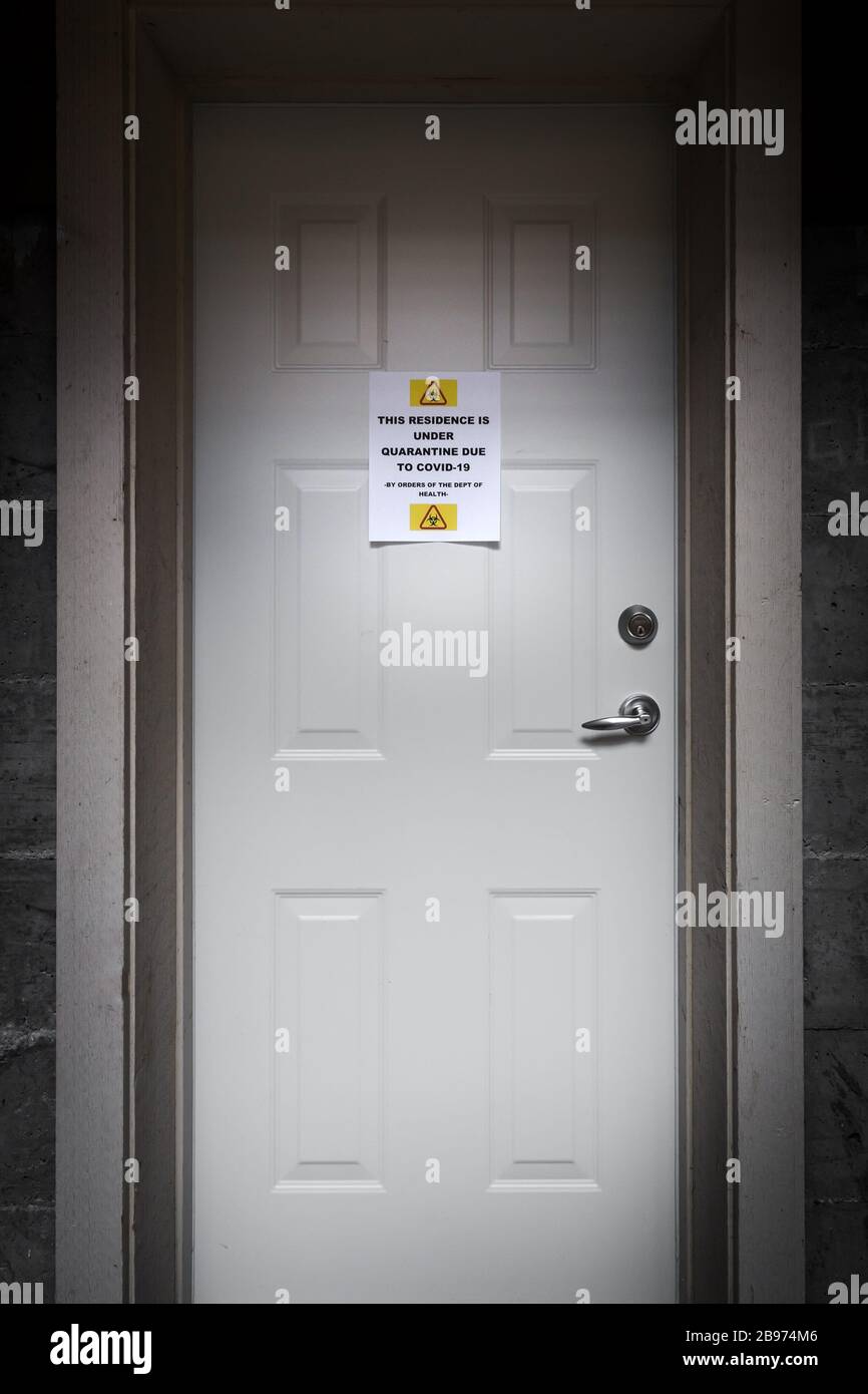 A self isolating residence with a quarantine sign on the front door warning of the Covid-19 virus. Stock Photo