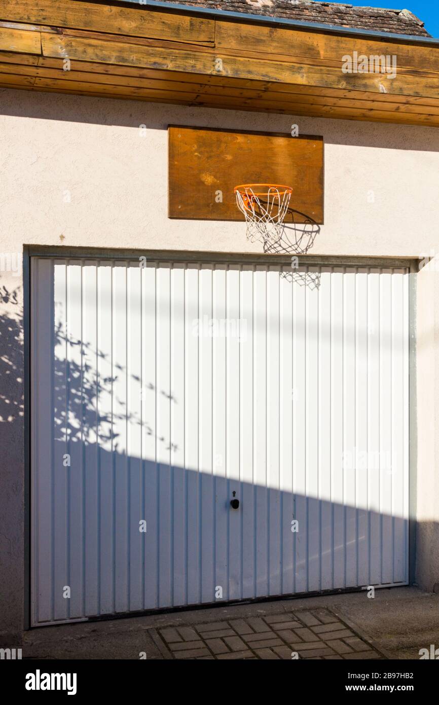 Closed garage door with basketball  hoop net fixed above Stock Photo