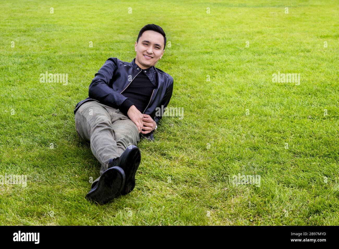 Asian yong man lying on the grass Stock Photo
