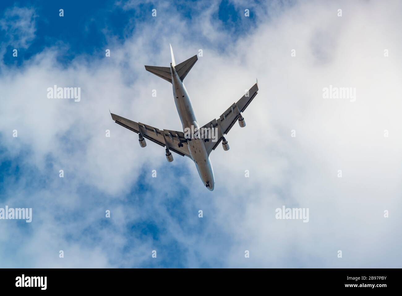 Passenger jet plane in the blue sky with clouds Stock Photo - Alamy