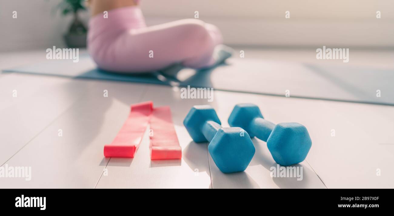 Fitness equipement for strength training at home - yoga woman exercising on exercise mat with weights and resistance bands easy fit active lifestyle Stock Photo