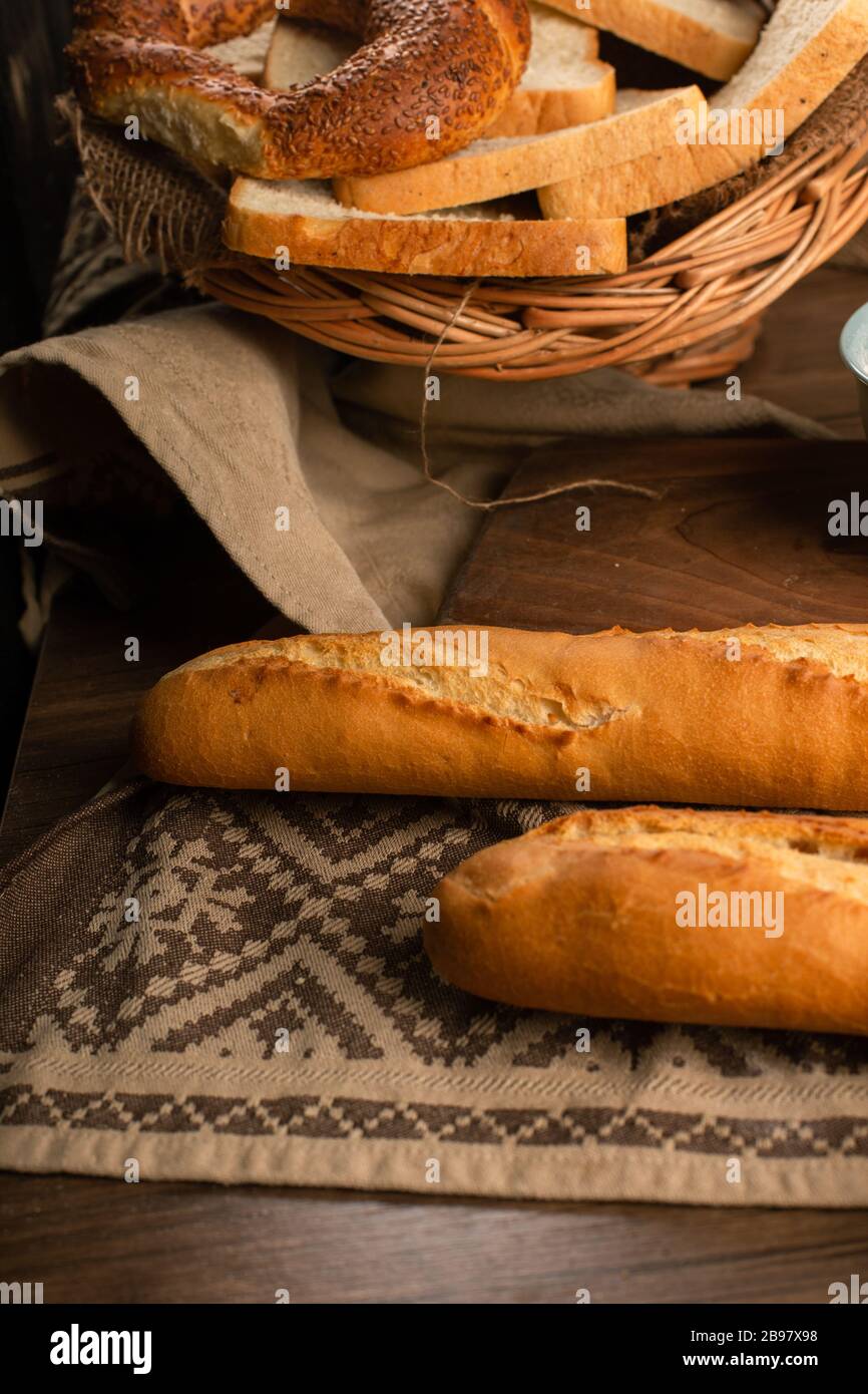 French baguette with slices of bread and bagels in basket Stock Photo ...
