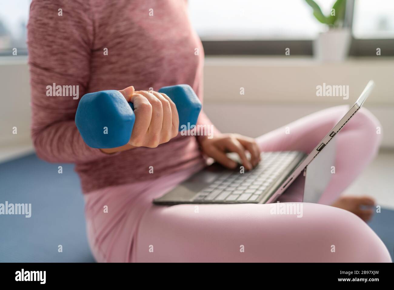 Fitness workout and working on laptop computer woman multitasking