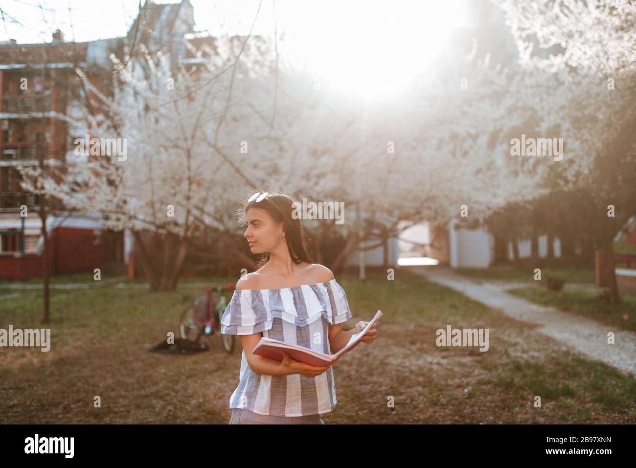 A beautiful young caucasian girl with a pink notebook in the park Stock ...