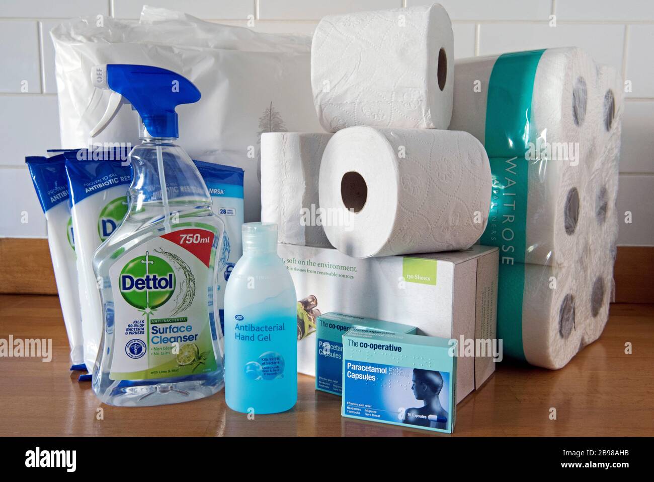 Antibacterial hand gel Dettol spray and surface wipes to combat coronavirus. Toilet rolls behind and Paracetamol Capsules. Covid-19 epidemic pandemic Stock Photo