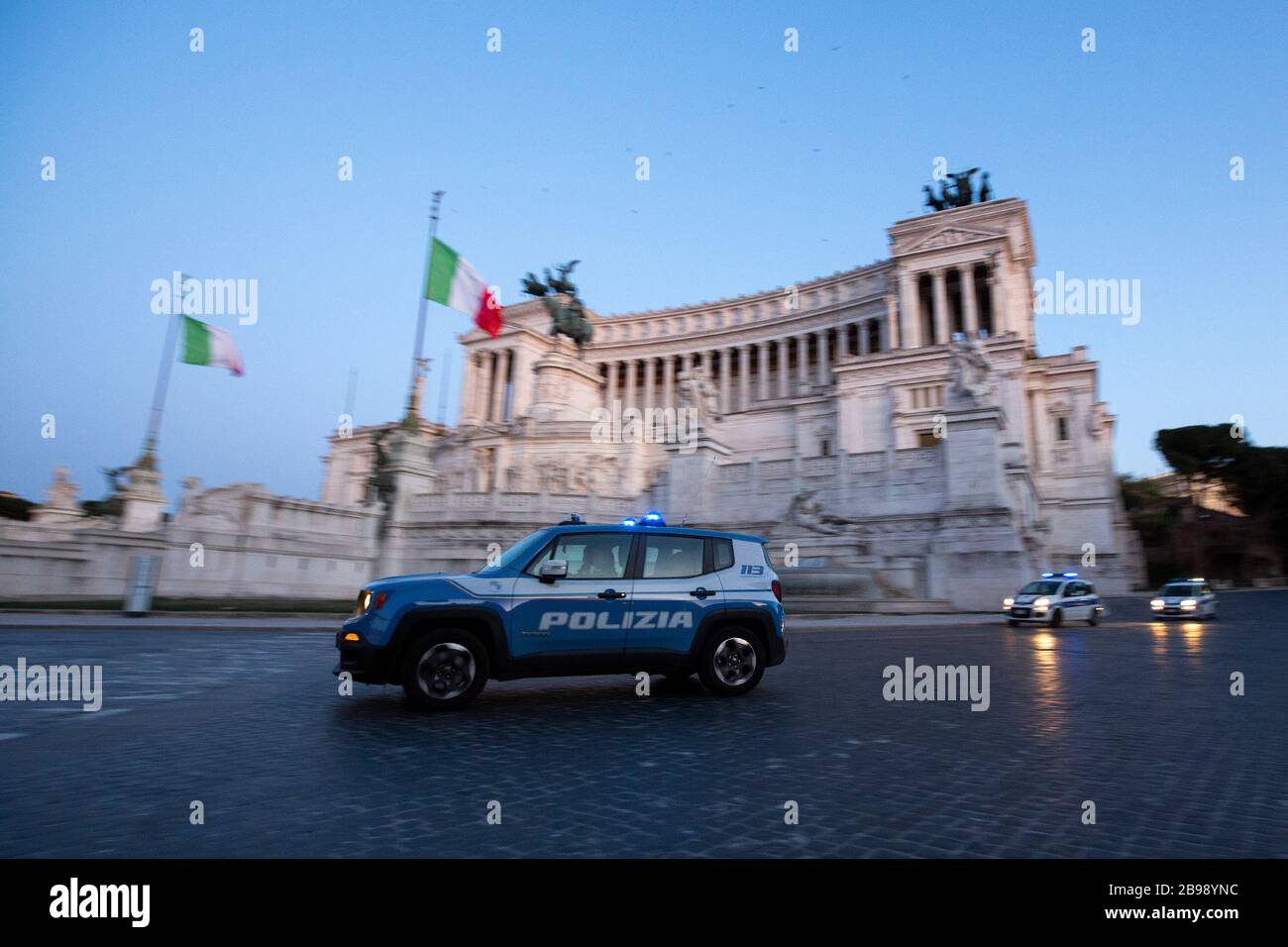 Roma, Italy. 23rd Mar, 2020. A police car pass in front of the Vittoriano in Piazza Venezia in Rome during the 14th day of lockdown imposed nationwide by the Italian government that tries to tackle the coronavirus outbreak. Every movements in the citiies are restricted, and streets usually filled with life and traffic are almost empty (Photo by Giuseppe Fama/Pacific Press) Credit: Pacific Press Agency/Alamy Live News Stock Photo