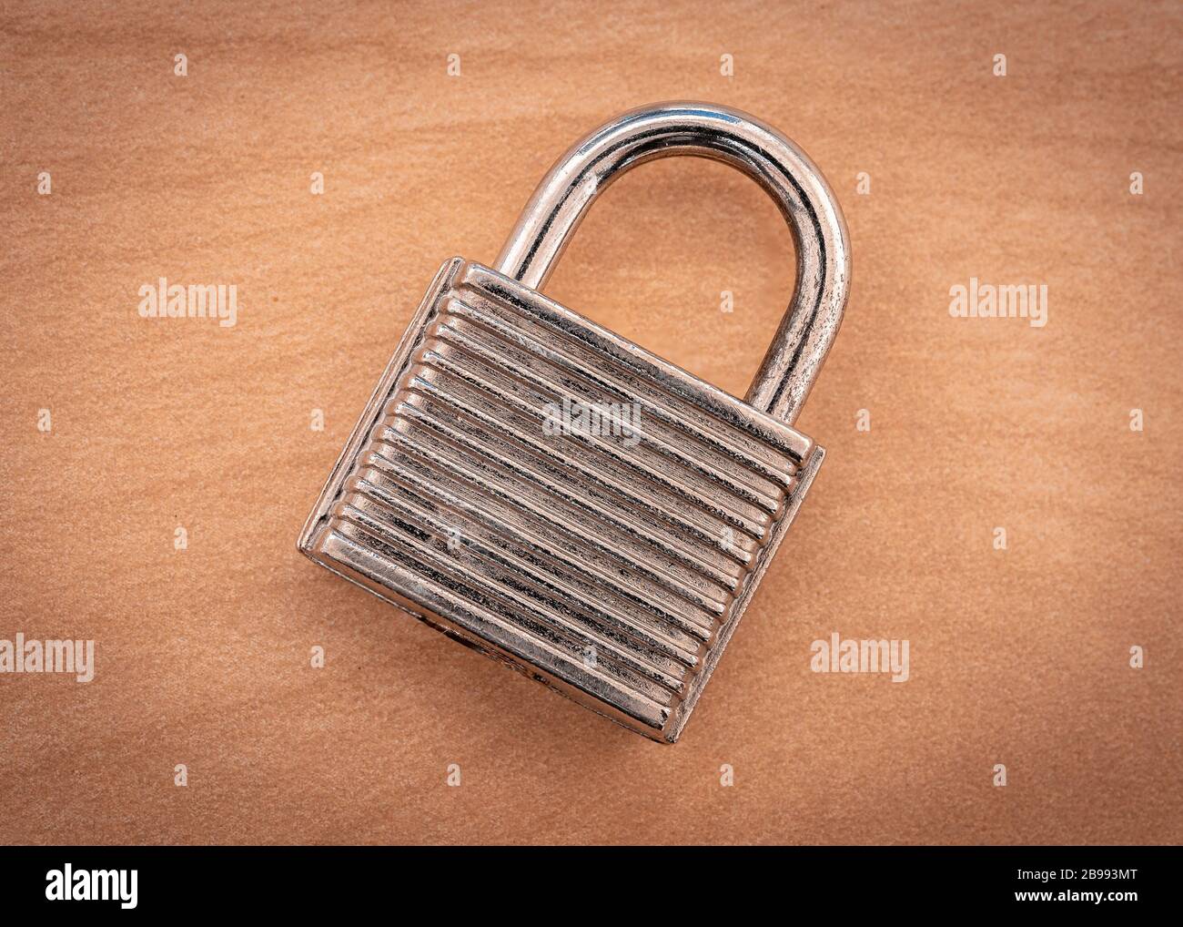 A closed padlock on a wooden surface Stock Photo