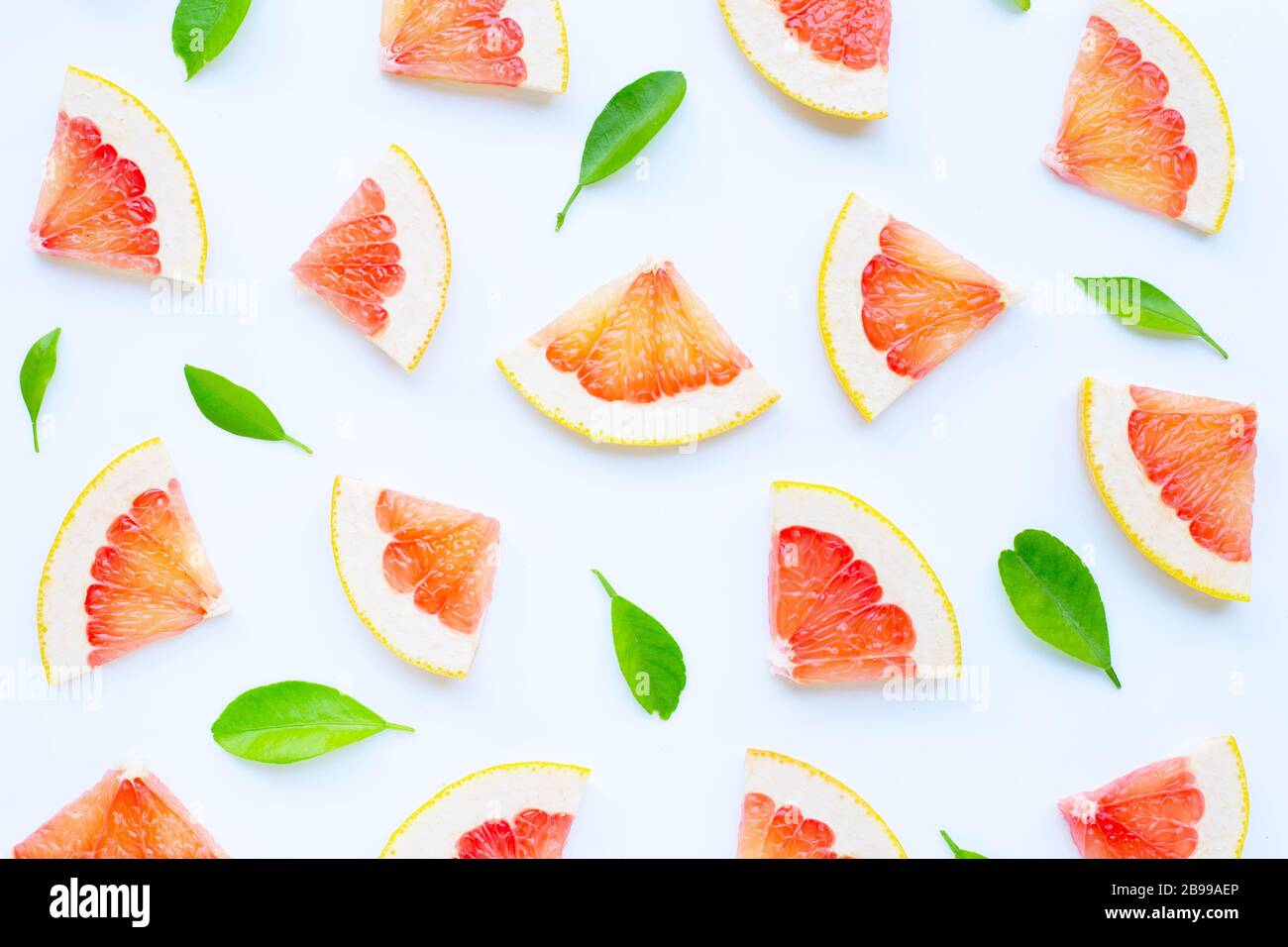 High vitamin C. Juicy grapefruit slices with leaves on white background. Stock Photo