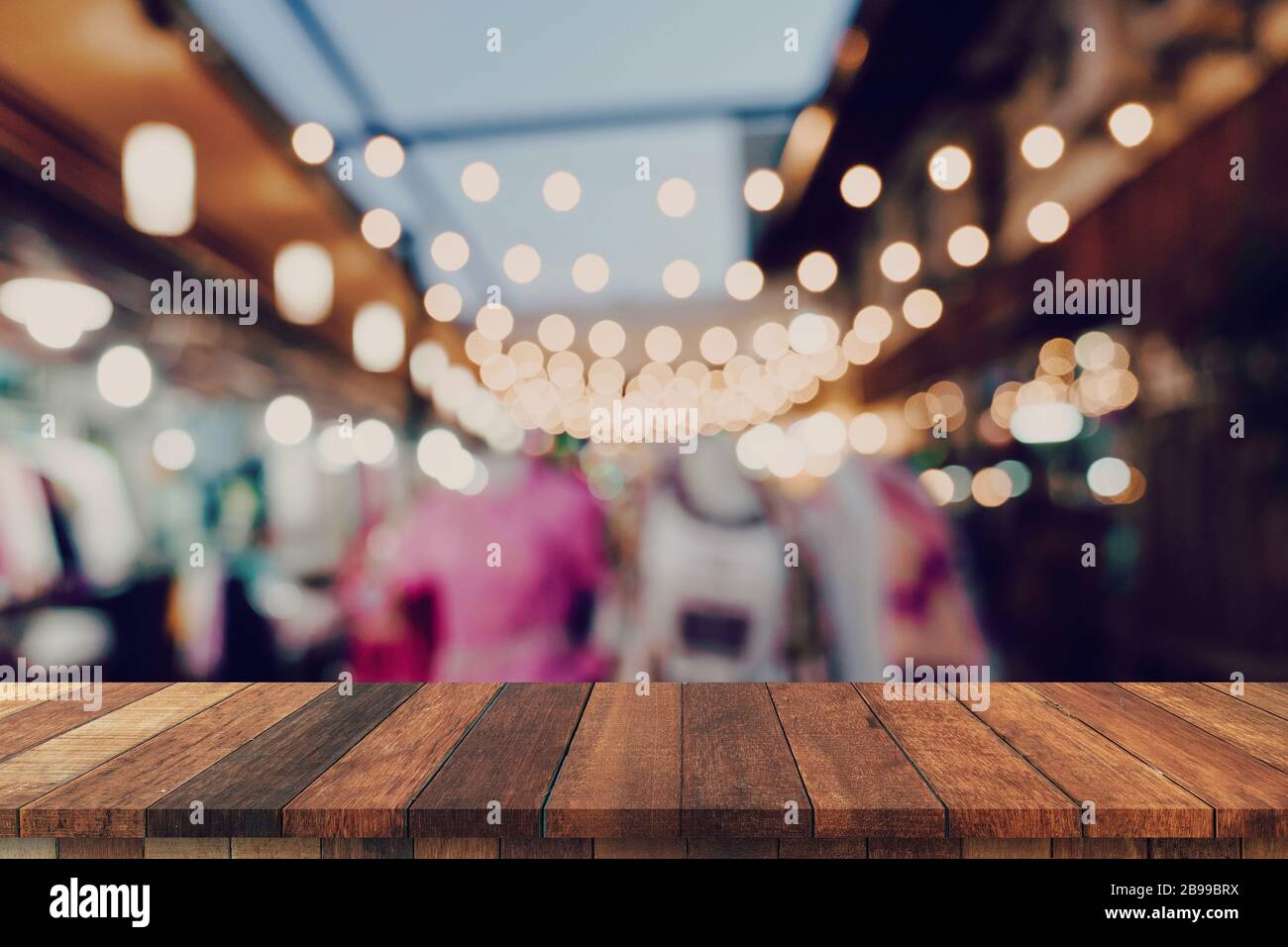 Empty wooden table and blurred background at night market festival ...