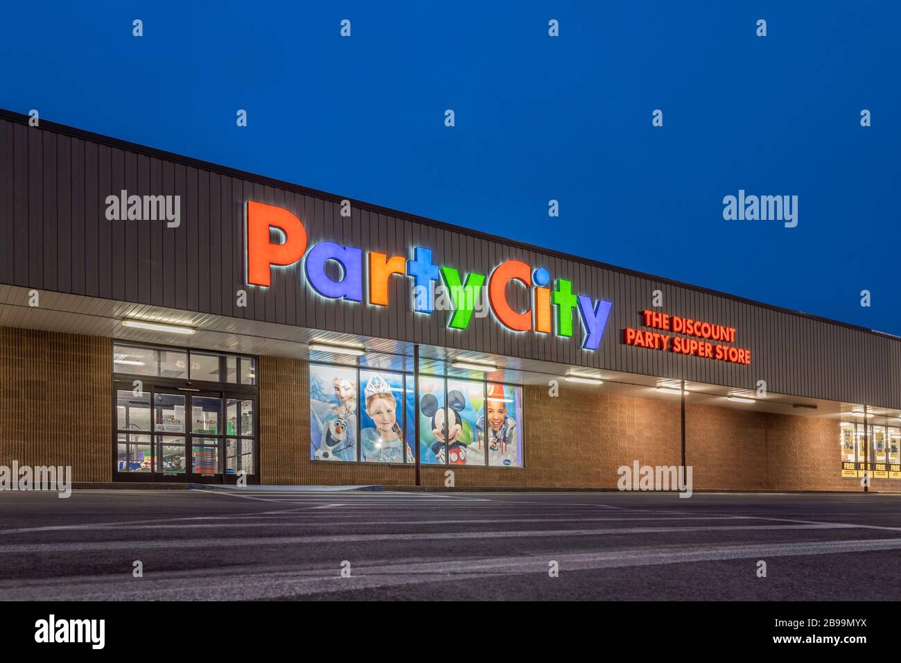 New Hartford, New York - Mar 19, 2020: Night View of Party City Discount The Super Store Exterior. Party City is an American Retail Chain of Party Sup Stock Photo