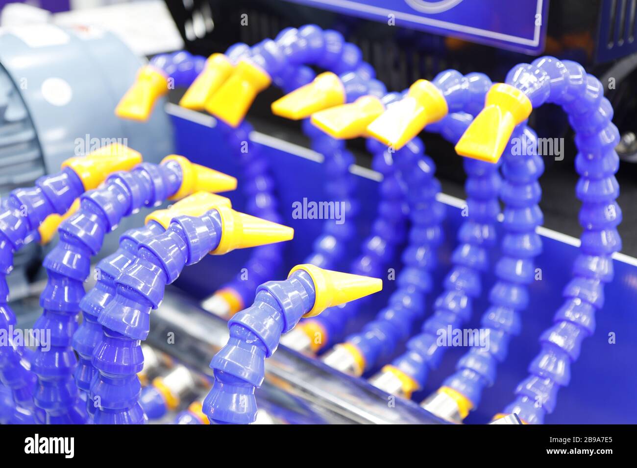 Flexible plastic nozzle tube for feeding liquid in manufacturing process such as machining  ; industrial equipment background Stock Photo