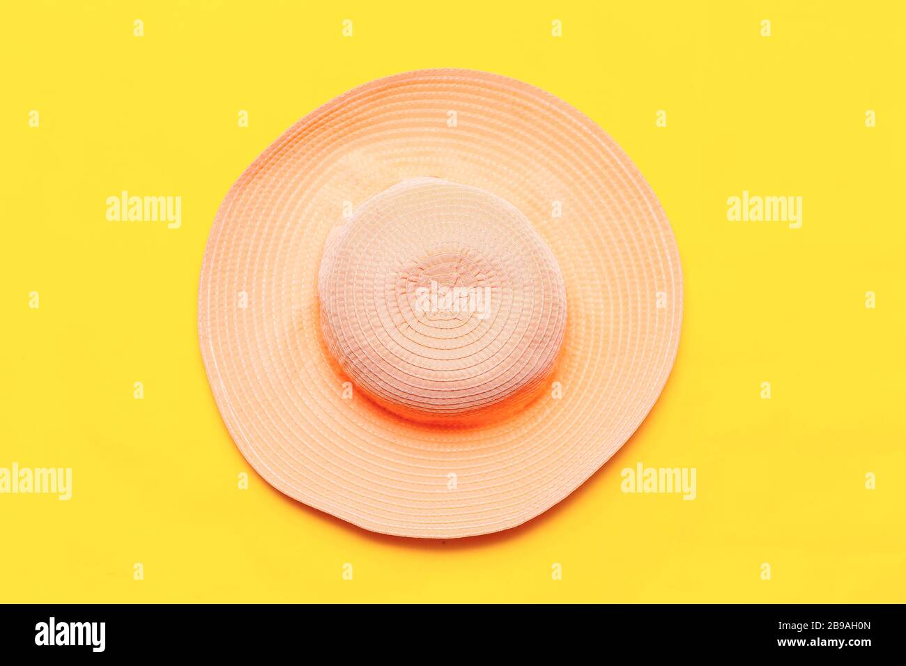 purple summer hat on a yellow background. top view flatlay copyspace