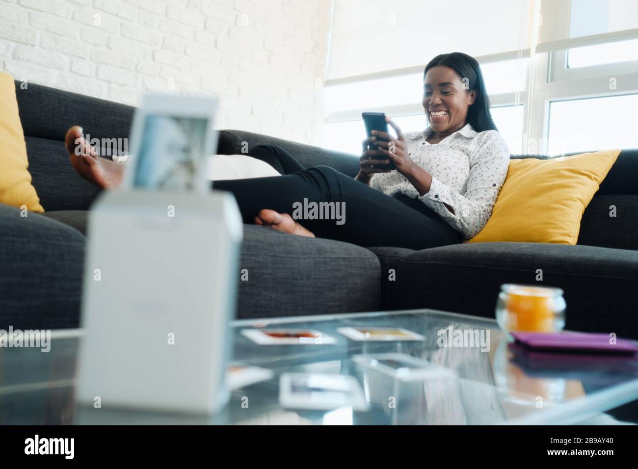 Black Woman Using Portable Wi-Fi Printer For Printing Pictures Stock Photo