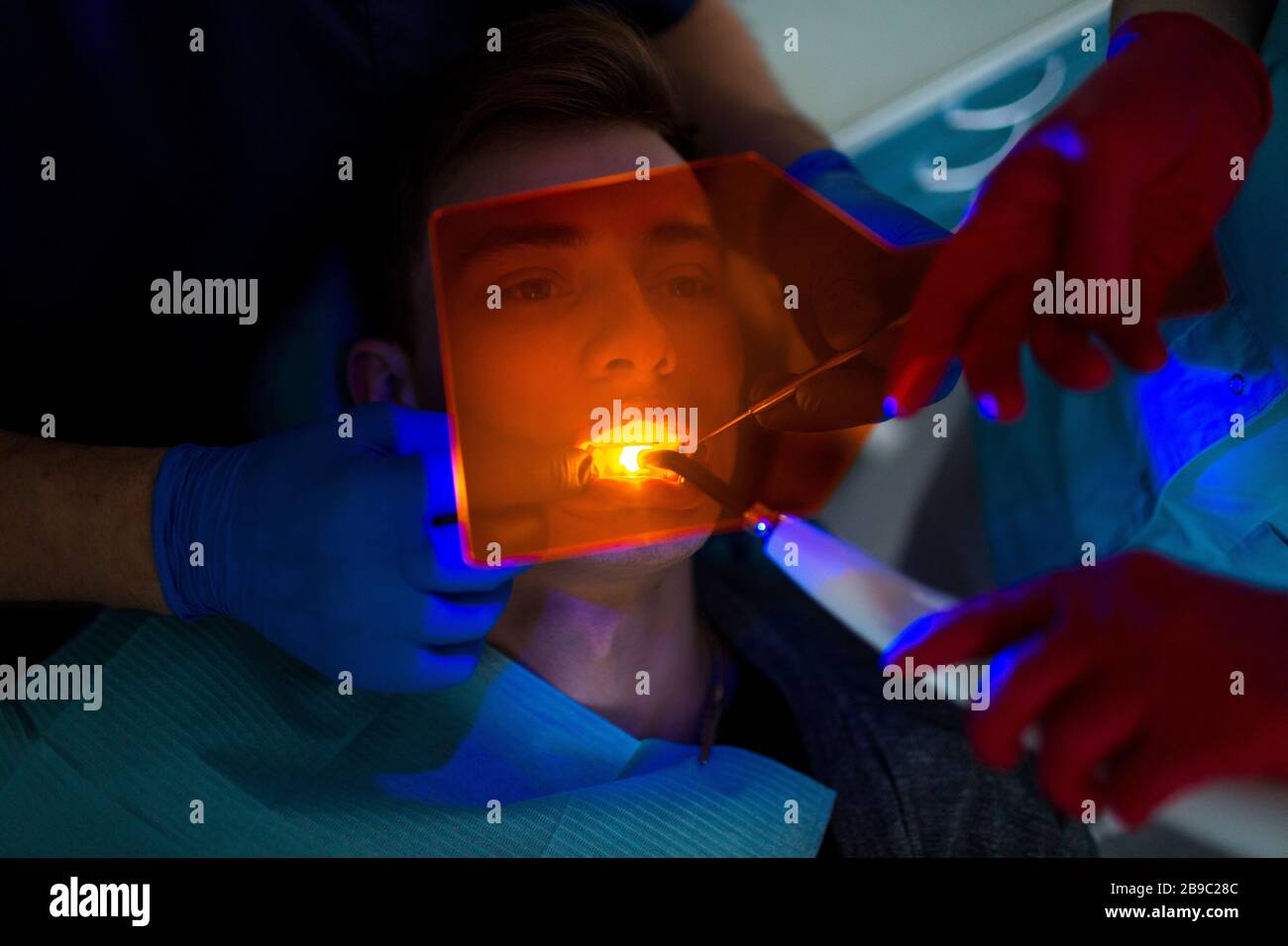 Dentistry. Dentist and patient. Light curing seal. UV dental lamp and