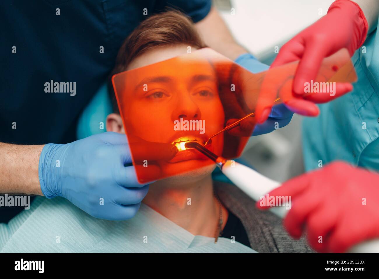 Dentistry. Dentist and patient. Light curing seal. UV dental lamp and