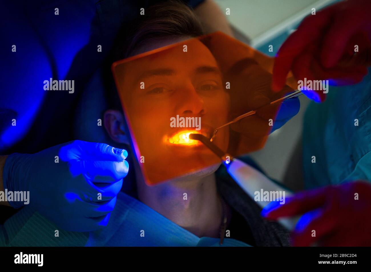 Dentistry. Dentist and patient. Light curing seal. UV dental lamp and