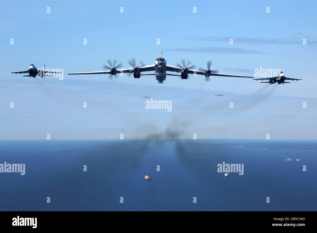 Tu-142MZ airplane in formation with Su-33 jets of the Russian Navy over the Gulf of Finland. Stock Photo