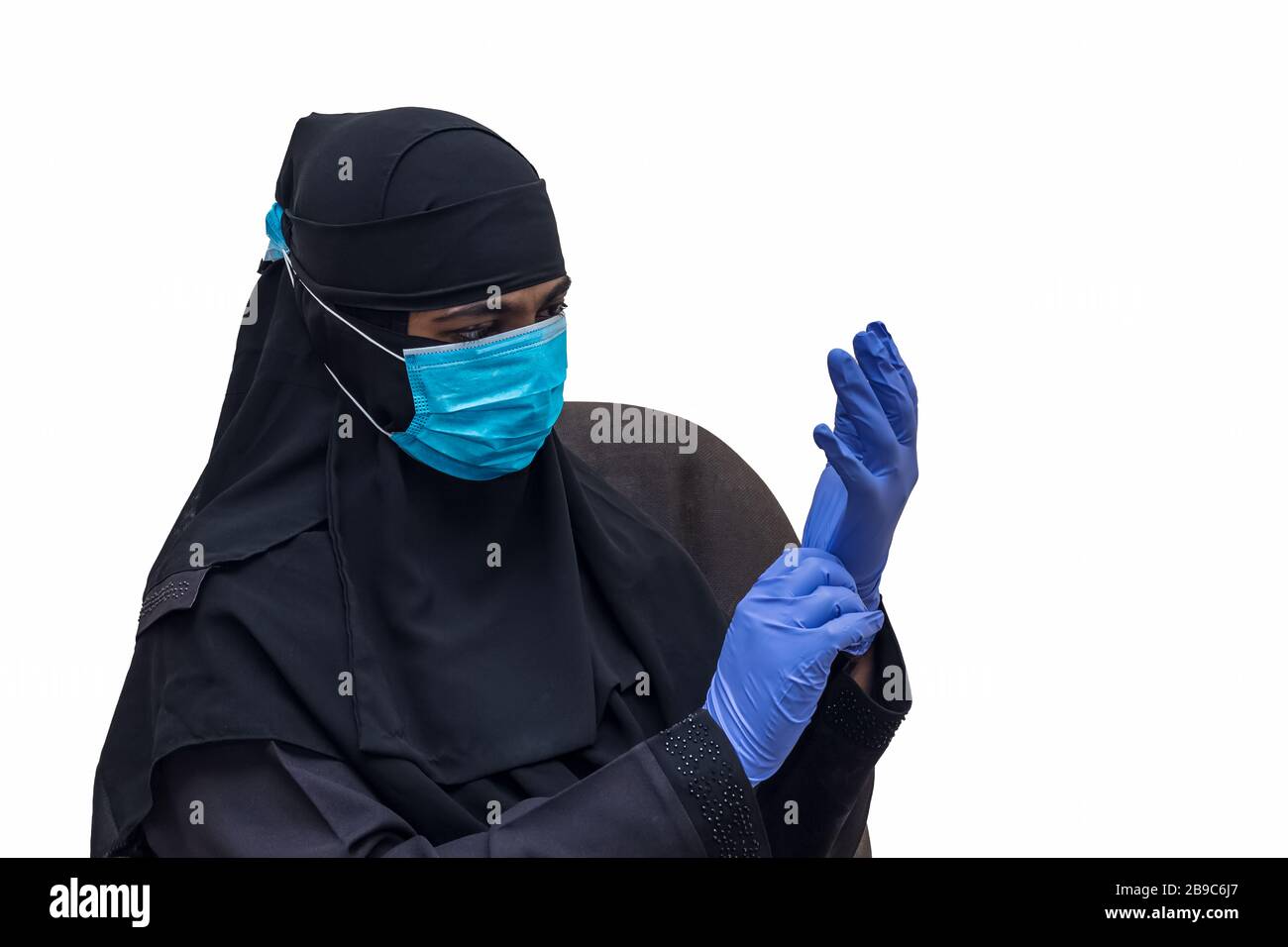 Muslim woman wearing medical face mask with hand gloves - Stay in home, Be safe and safe others. Concept of COVID-19 or Coronavirus quarantine. Stock Photo