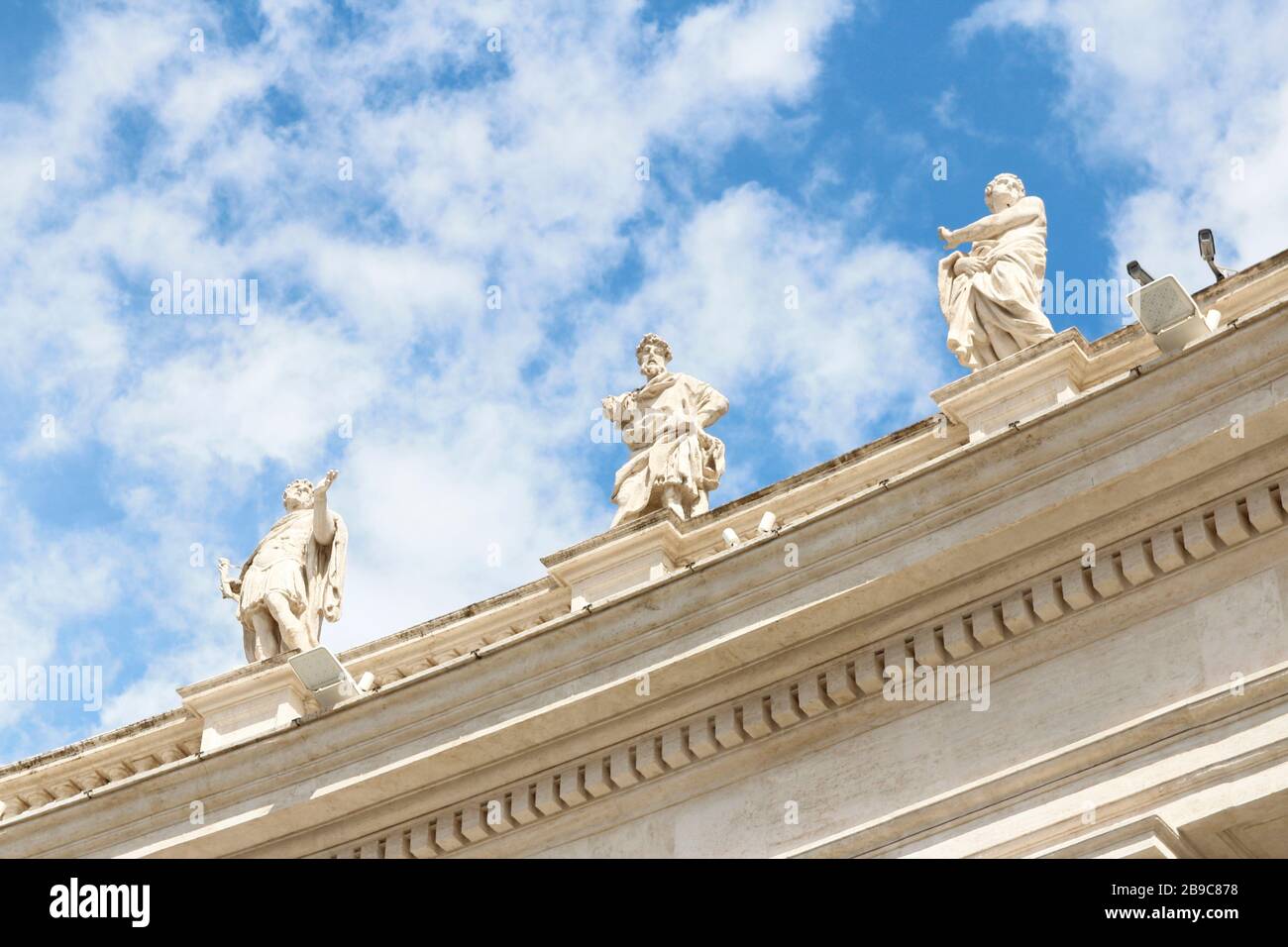 Saint Statues on the colonnades of St Peter's Square with blue sky and ...