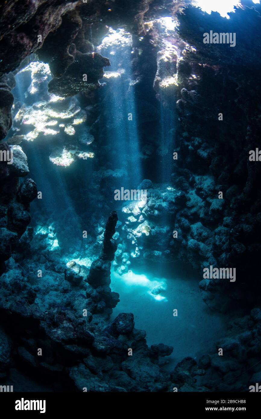 Sunbeams penetrate the cave entrance from above, Red Sea. Stock Photo