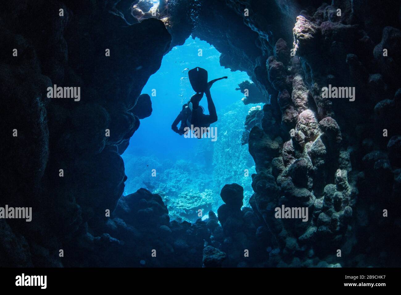 A diver exits an underwater cave, Red Sea. Stock Photo