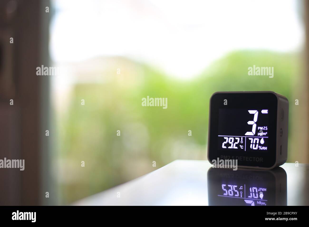 air quality sensor placing on a table indoor. sensor found small amount of air pollution of PM 2.5 the poisonous harmful particulate matter invisible Stock Photo