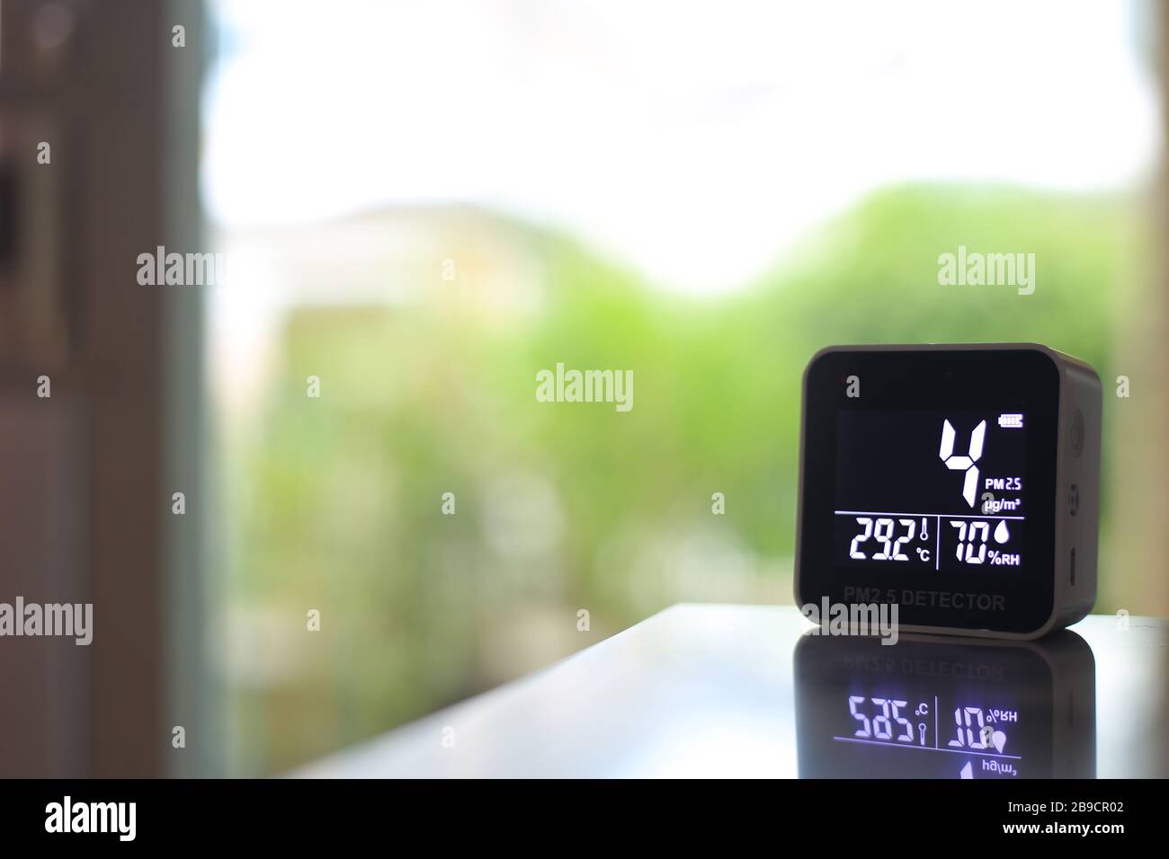 air quality sensor placing on a table indoor. sensor found small amount of air pollution of PM 2.5 the poisonous harmful particulate matter invisible Stock Photo