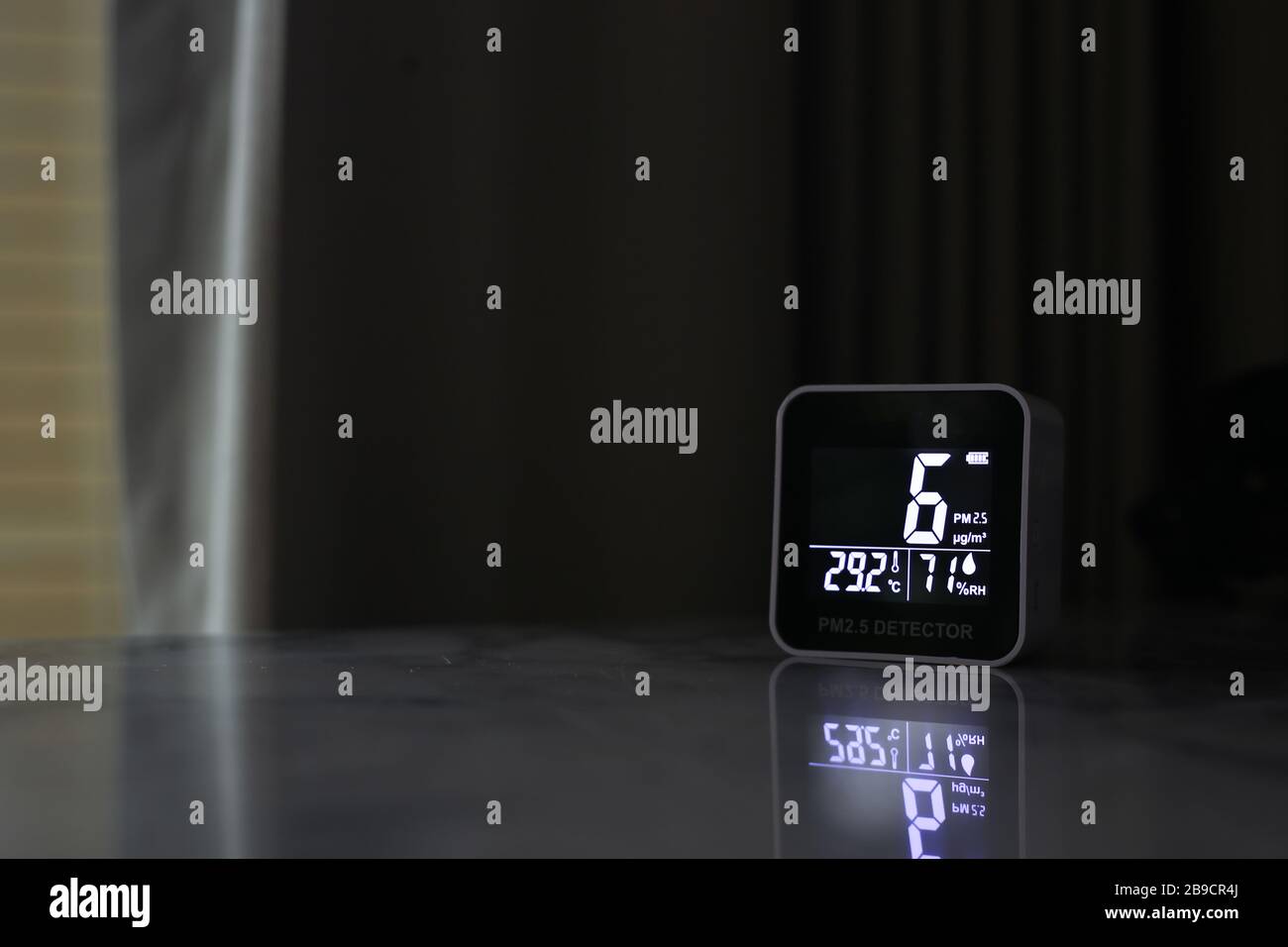 air quality sensor placing on a table indoor. sensor found small amount of air pollution of PM 2.5 the poisonous harmful particulate matter invisible Stock Photo