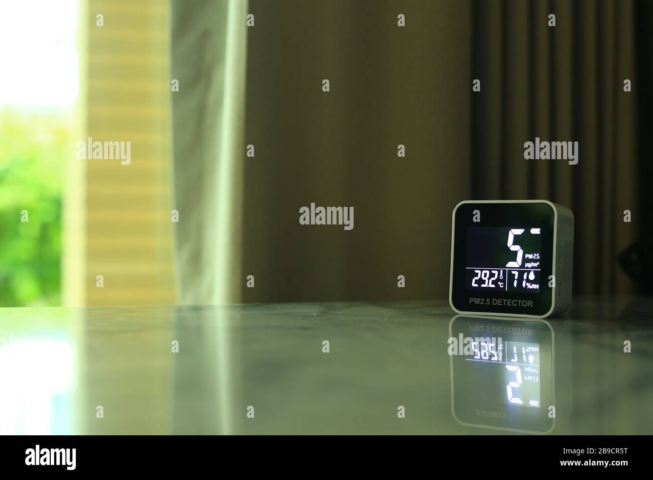 air quality sensor placing on a table indoor. sensor found small amount of air pollution of PM 2.5 the poisonous harmful particulate matter invisible Stock Photo