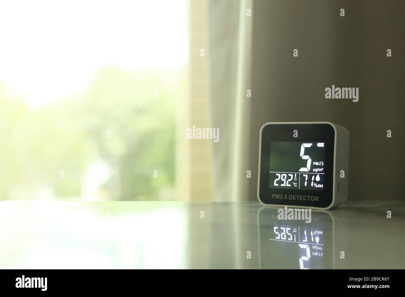 air quality sensor placing on a table indoor. sensor found small amount of air pollution of PM 2.5 the poisonous harmful particulate matter invisible Stock Photo