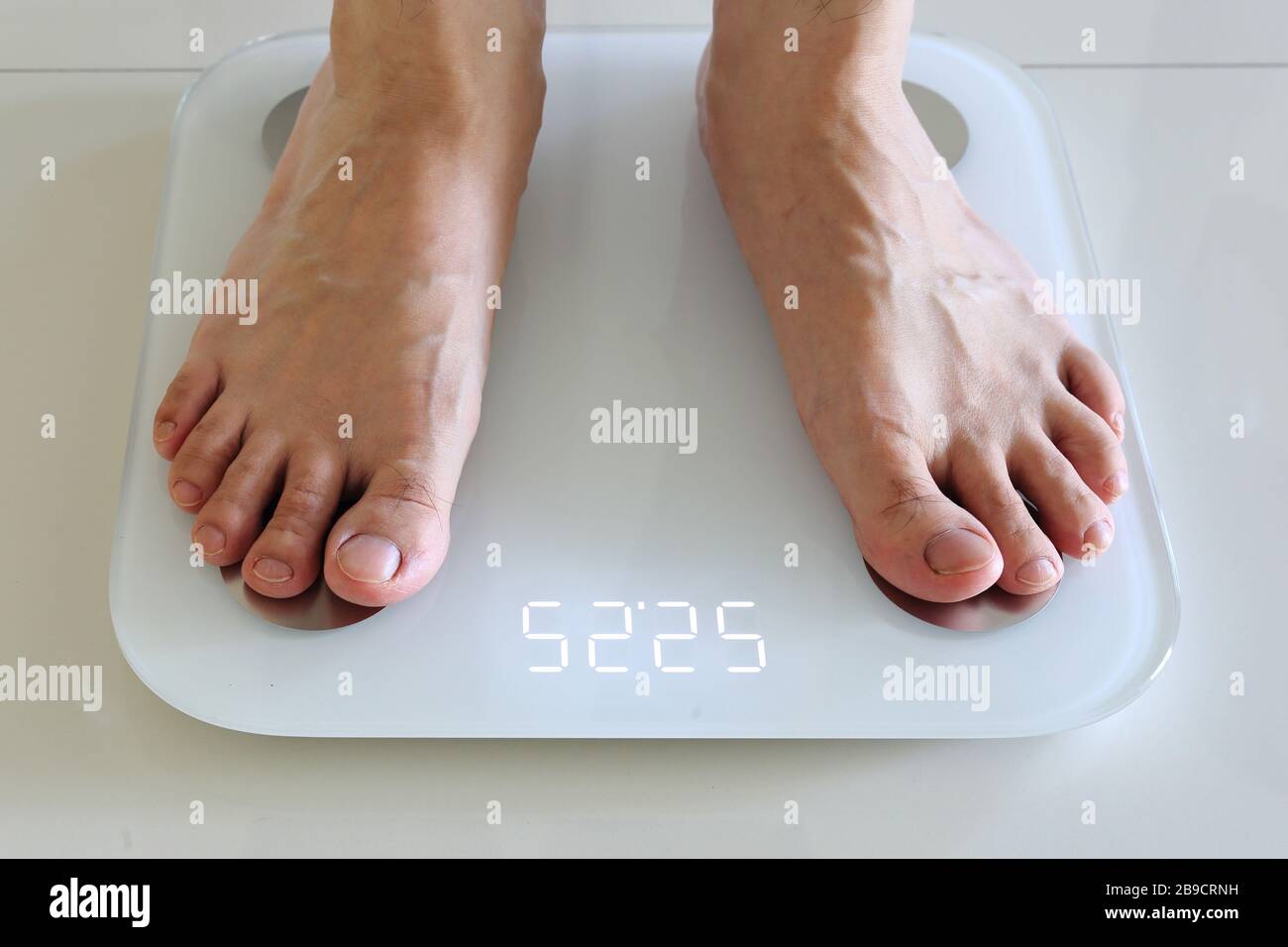 Obesity And Weightloss. Feet On Weight Scale. Pounds Stock Photo - Alamy