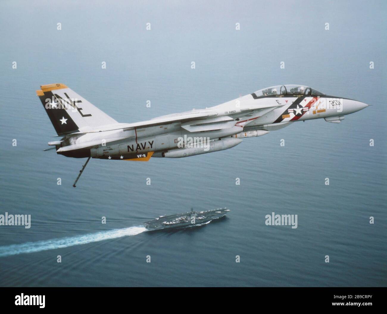 An F-14 Tomcat from VF-2 above the USS Ranger in the Indian Ocean. Stock Photo