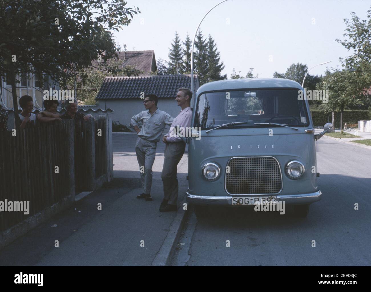 Two Men In Front Of A Ford Fk 1000 Talking To Three Women Standing Behind A Fence Automated Translation Stock Photo Alamy