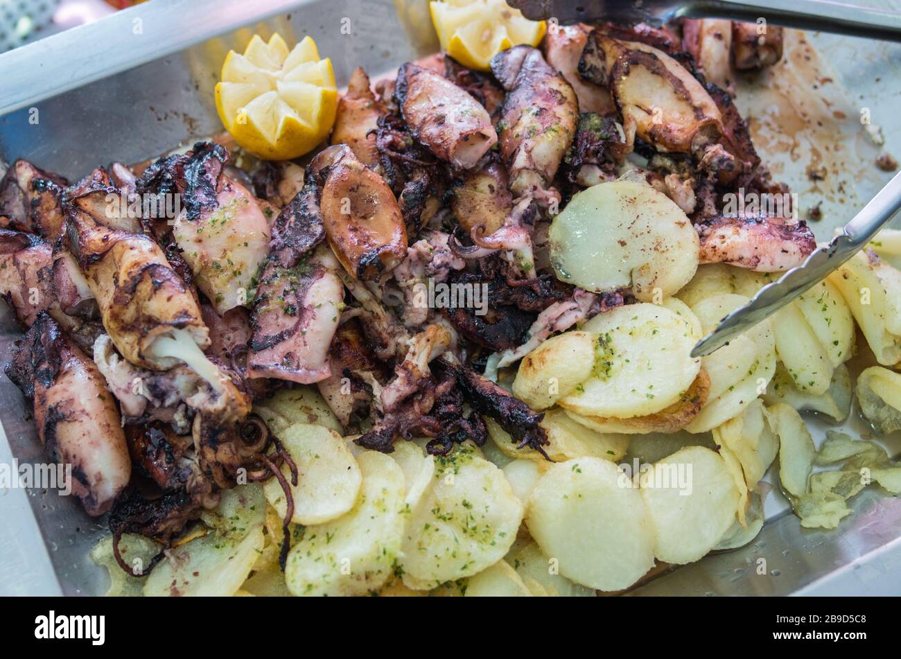 Grilled baby squid with roasted potatoes, lemon, marinated with extra